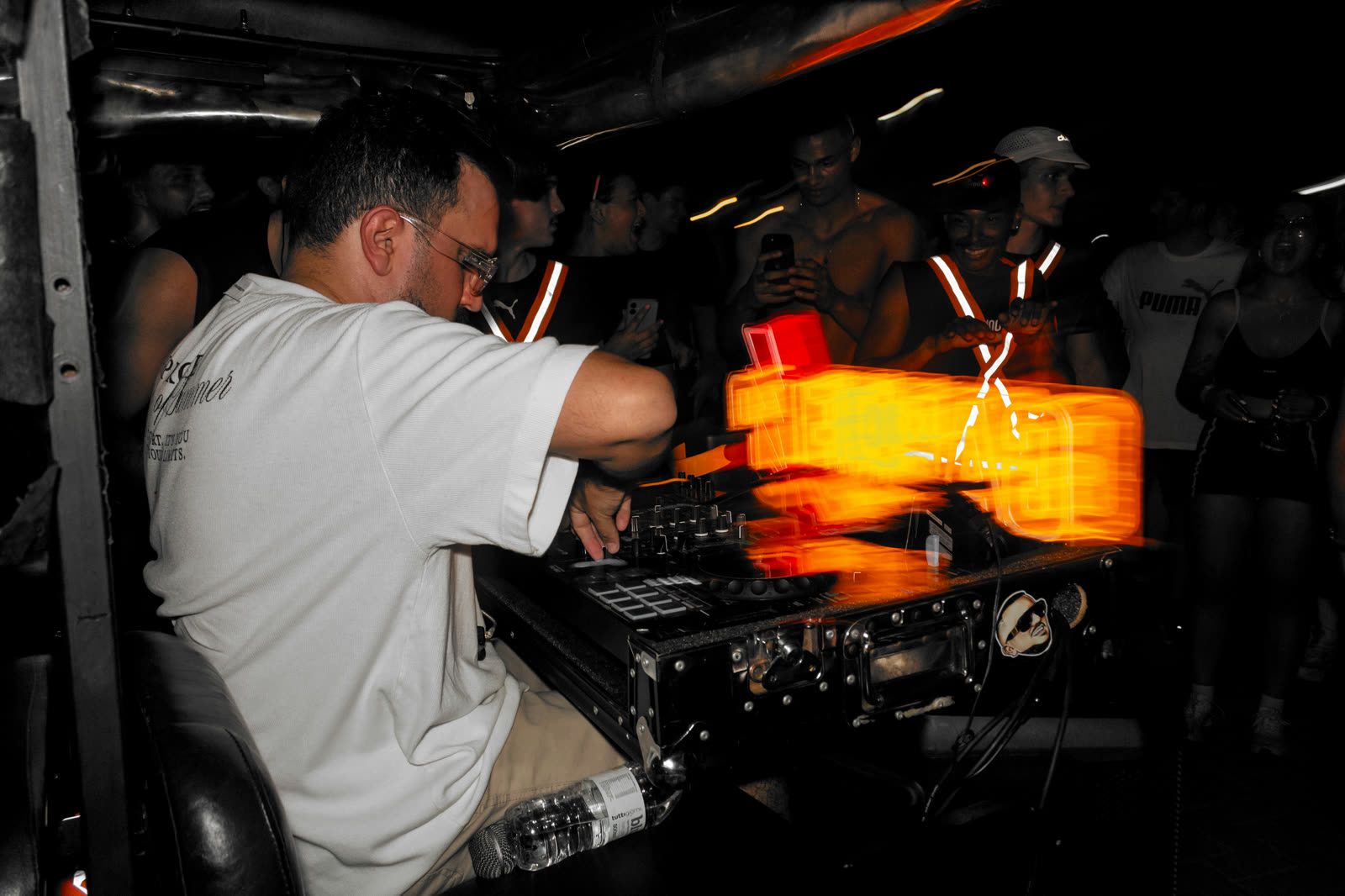 DJ mixando à noite com rastro de luz laranja