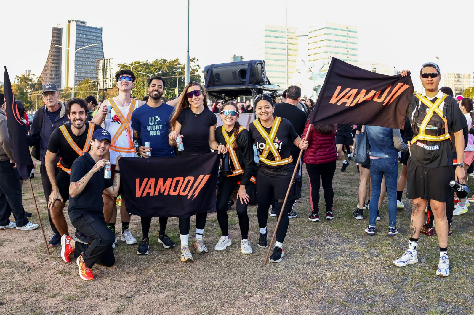 Grupo do Vamoo posando com a bandeira depois da corrida